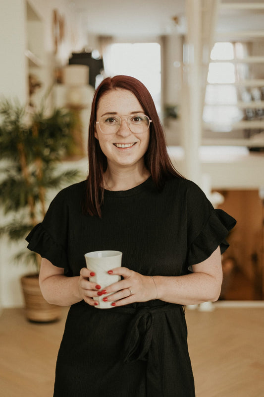 Vrouw werkt als VA thuis aan laptop met notitieboek – bezig met een dagelijkse opdracht uit een 30-dagen challenge.